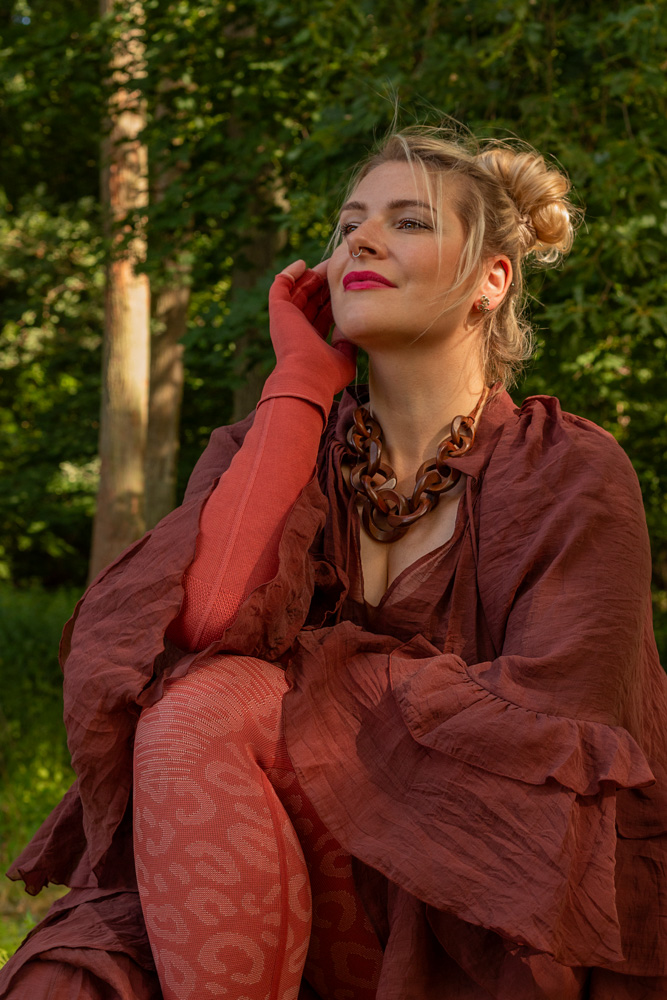 Caroline Sprott Power Sprotte zeigt Curvy Mode als Lipödem Outfit in Flachstrick-Kompression mit seitlicher Naht von medi in Rostrot mit Fashion-Element "Wild"