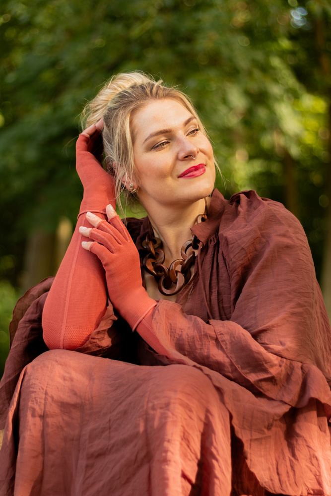 Caroline Sprott Power Sprotte zeigt Plus Size Mode als Lipödem Outfit in Flachstrick-Kompression mit seitlicher Naht von medi in Rostrot mit Fashion-Element "Wild"