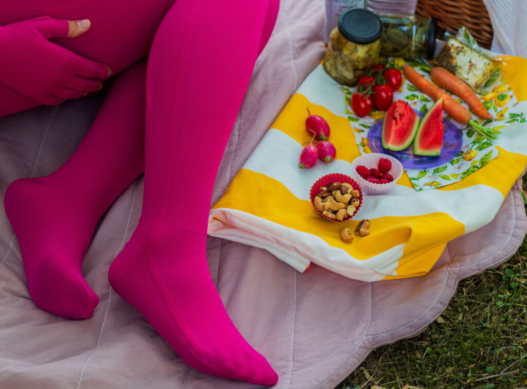 mediven 550 in Magenta mit seitlicher Naht beim langen Sitzen auf einer Picknickdecke
