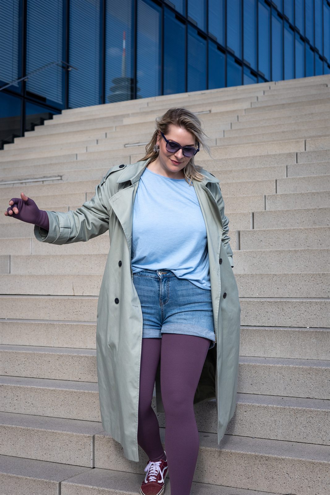 Kompressionsstrumpfhose in Samtviolett mit Jeansshorts und salbeigrünem Trenchcoat